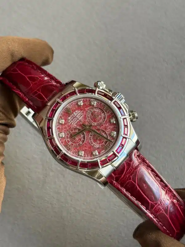 Silver-toned chronograph wristwatch with a red textured dial and red leather strap.