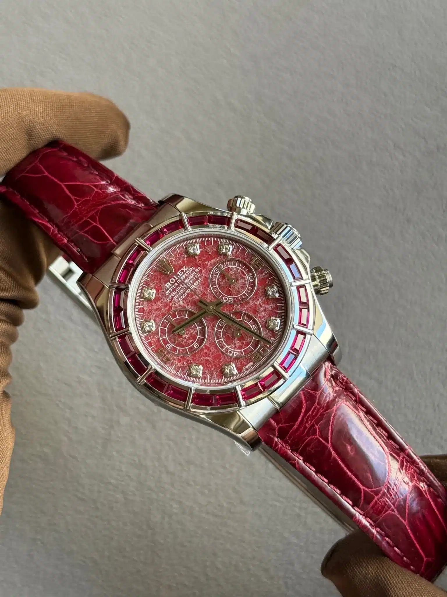 Silver-toned chronograph wristwatch with a red textured dial and red leather strap.