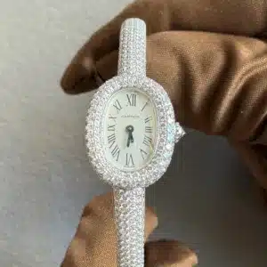 Diamond-encrusted Cartier watch with a Roman numeral dial held by a gloved hand.
