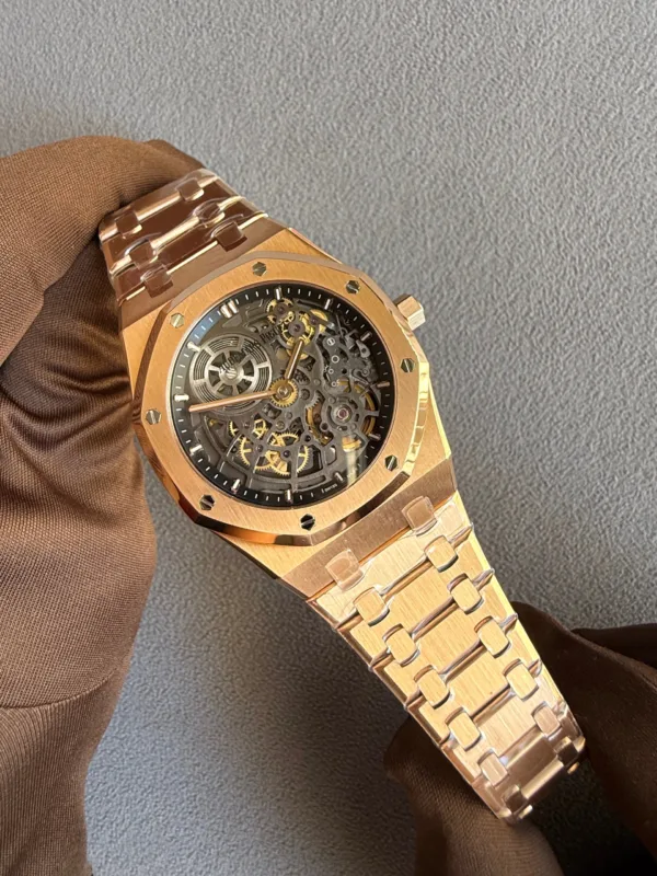 Rose-gold skeleton wristwatch with visible gears, held by a gloved hand.