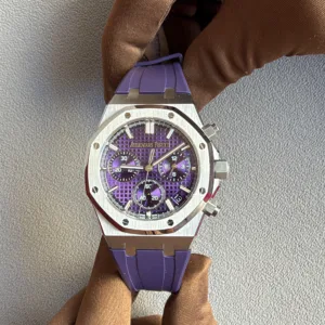 Purple-dial Audemars Piguet Royal Oak watch with a stainless steel case and purple strap resting on a brown fabric surface.
