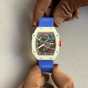 Close-up of a white Richard Mille skeleton watch on a bright blue strap, held by brown gloves, showcasing the intricate inner mechanism through the open dial.
